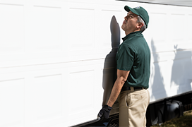 A PDS expert lifting a white garage door.
